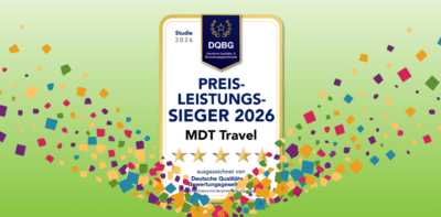 Auszeichnung ‚Preis-Leistungssieger 2026‘ der Deutschen Qualitäts- & Bewertungsgesellschaft (DQBG) für MDT Travel mit fünf goldenen Sternen, umgeben von buntem Konfetti auf grünem Hintergrund.